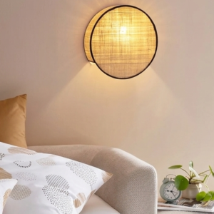 A four-panel product collage showcasing a low-profile, circular rattan wall sconce in various settings and configurations, featuring fine-woven natural cane fabric and contrasting minimalist trims.